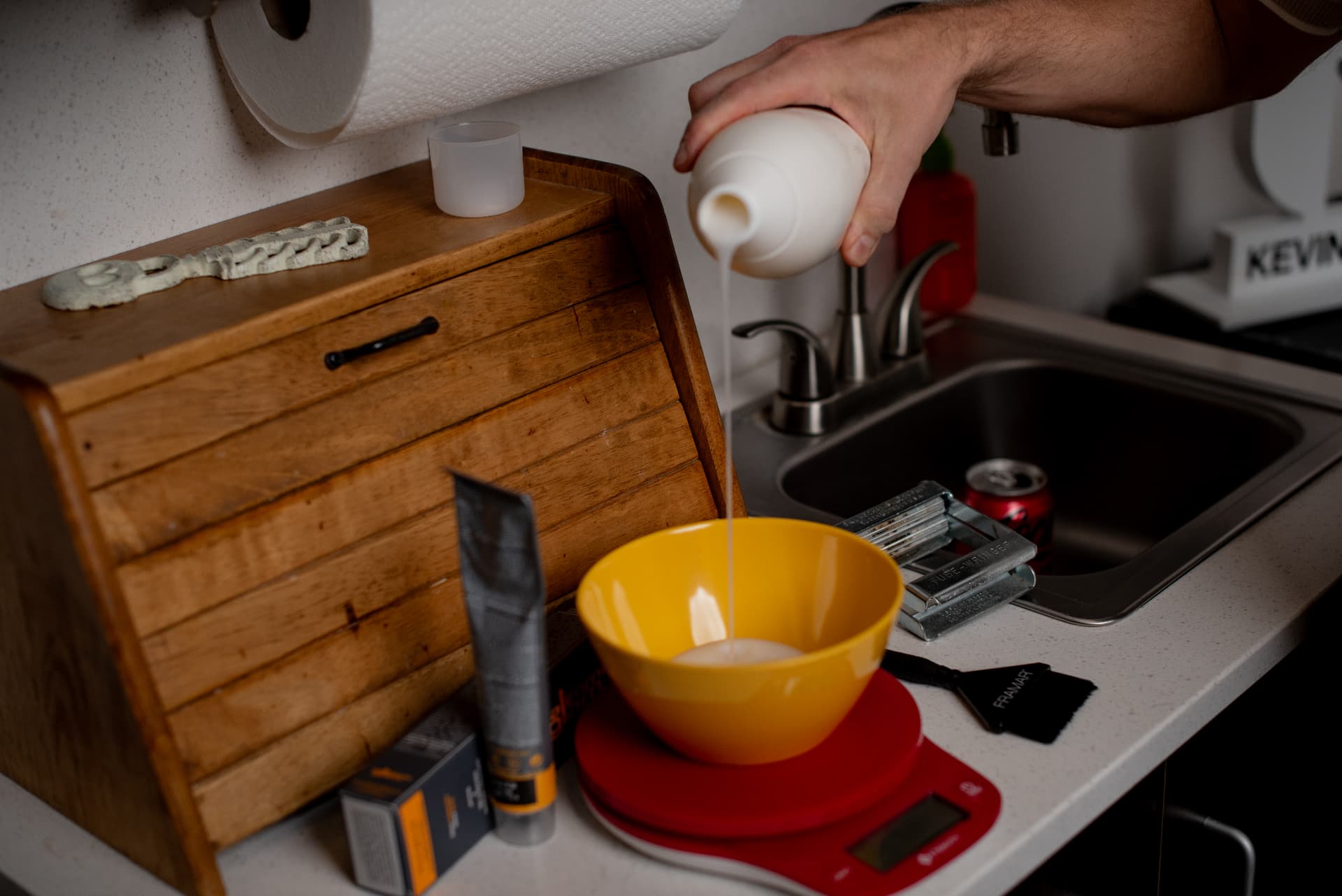 Developer pouring into a yellow mixing bowl on a scale.