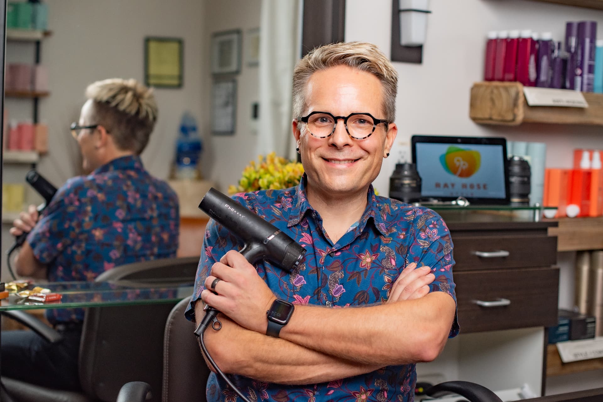 Ray Rose smiling with a blow dryer in hand in his salon suite.