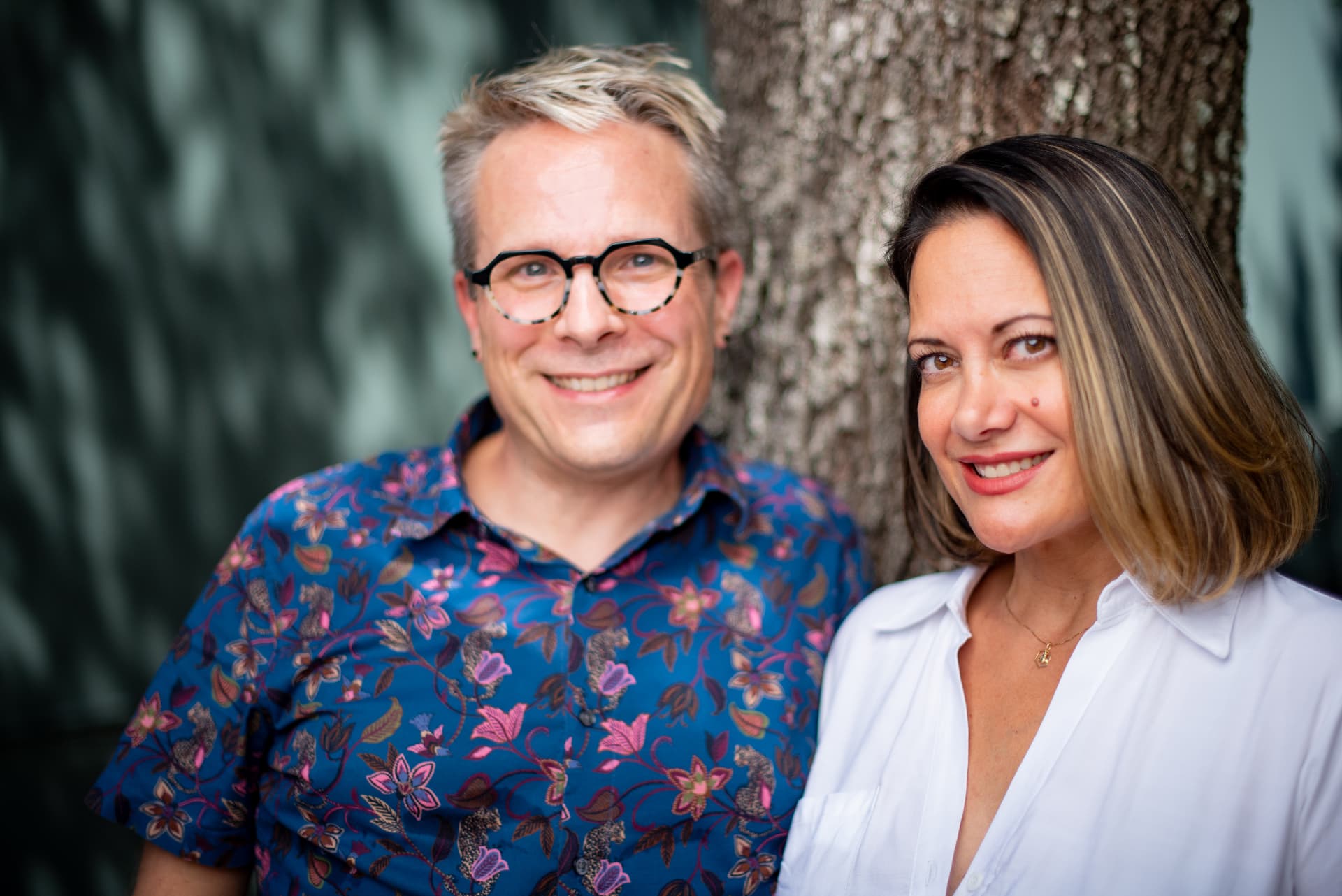 Ray and his guest smiling together against an oak tree after her appointment.